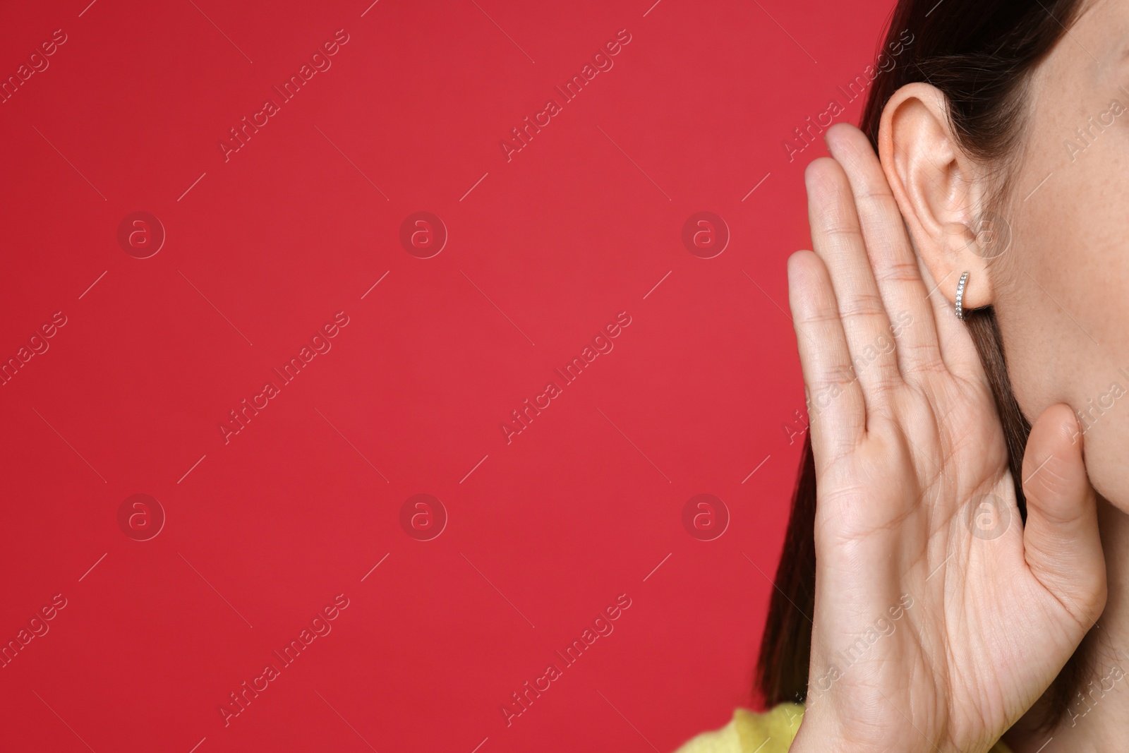 Photo of Woman showing hand to ear gesture on red background, closeup. Space for text