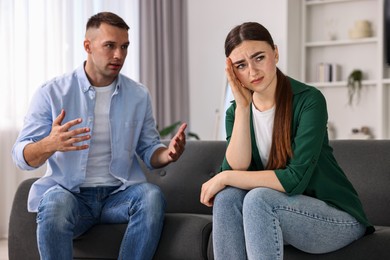 Upset woman ignoring her husband at home