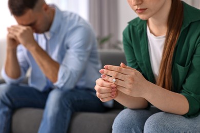 Woman taking off engagement ring after quarrel with her husband at home, closeup