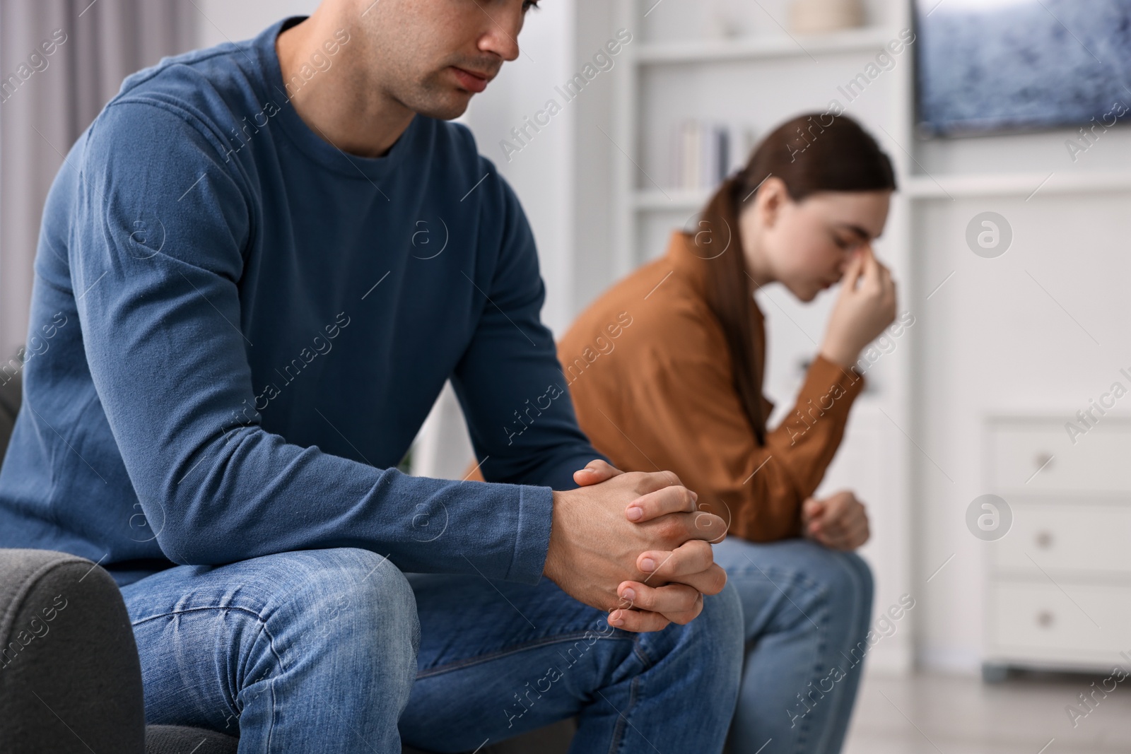 Photo of Offended couple ignoring each other at home, selective focus