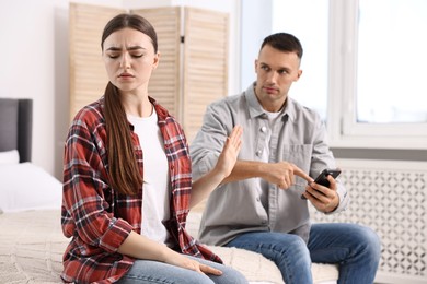 Photo of Tired woman stopping her husband at home, selective focus