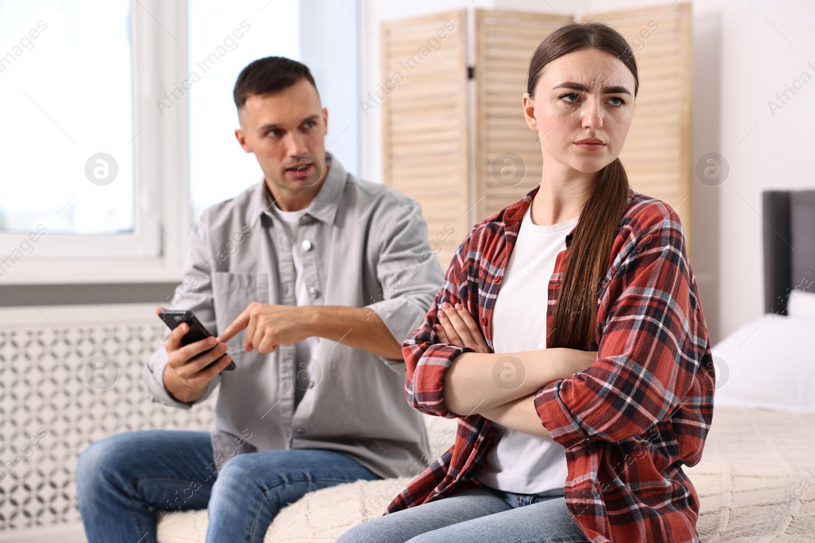 Photo of Upset woman ignoring her husband at home, selective focus