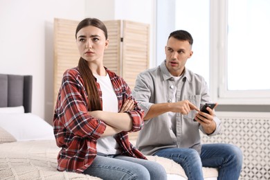 Upset woman ignoring her husband at home, selective focus