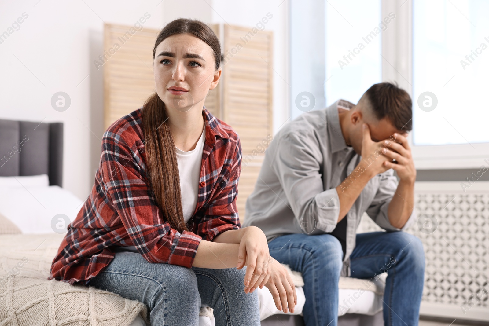 Photo of Offended couple ignoring each other at home