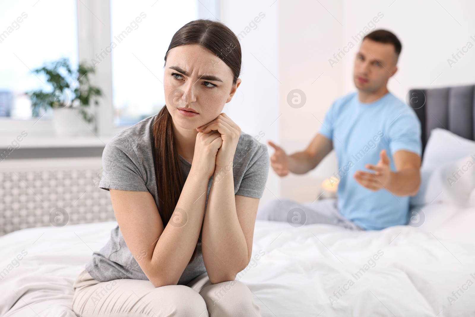 Photo of Upset woman ignoring her husband in bedroom, selective focus