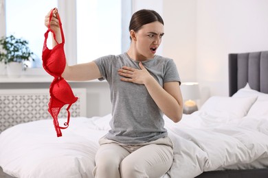 Photo of Surprised wife finding mistress bra in bedroom