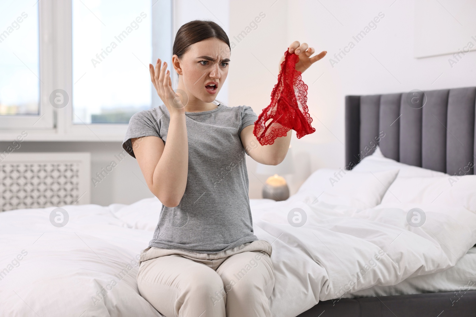 Photo of Surprised wife finding mistress panties in bedroom