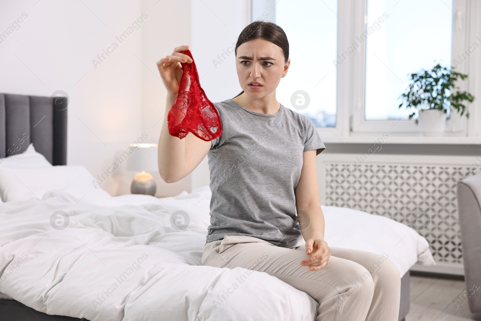 Photo of Surprised wife finding mistress panties in bedroom