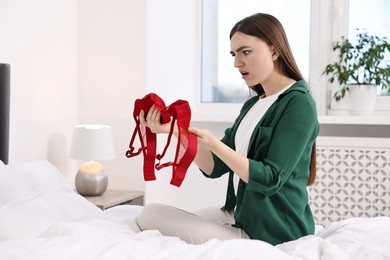 Photo of Surprised wife finding mistress bra in bedroom