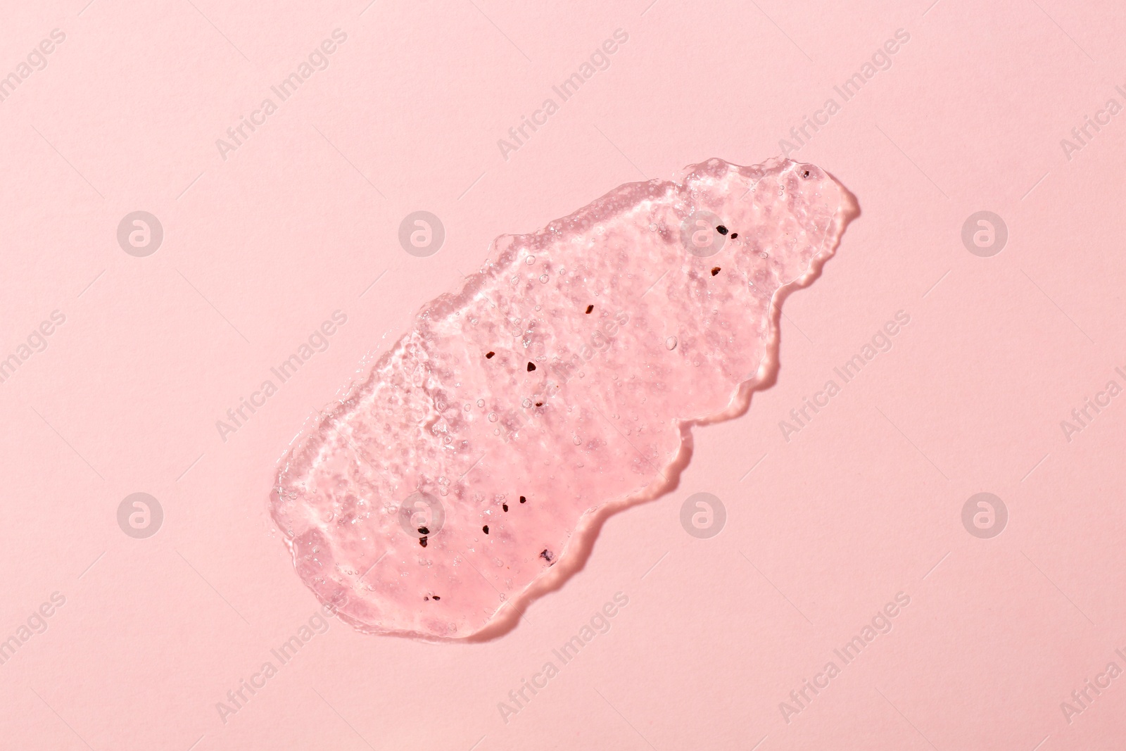 Photo of Smear of body scrub on light pink background, top view