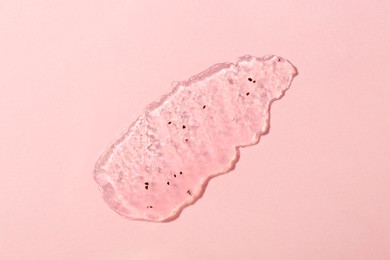 Photo of Smear of body scrub on light pink background, top view