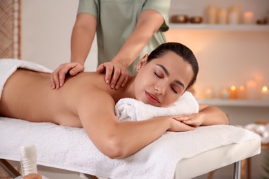 Photo of Young woman receiving massage in spa salon