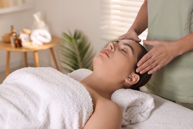 Photo of Young woman receiving massage in spa salon