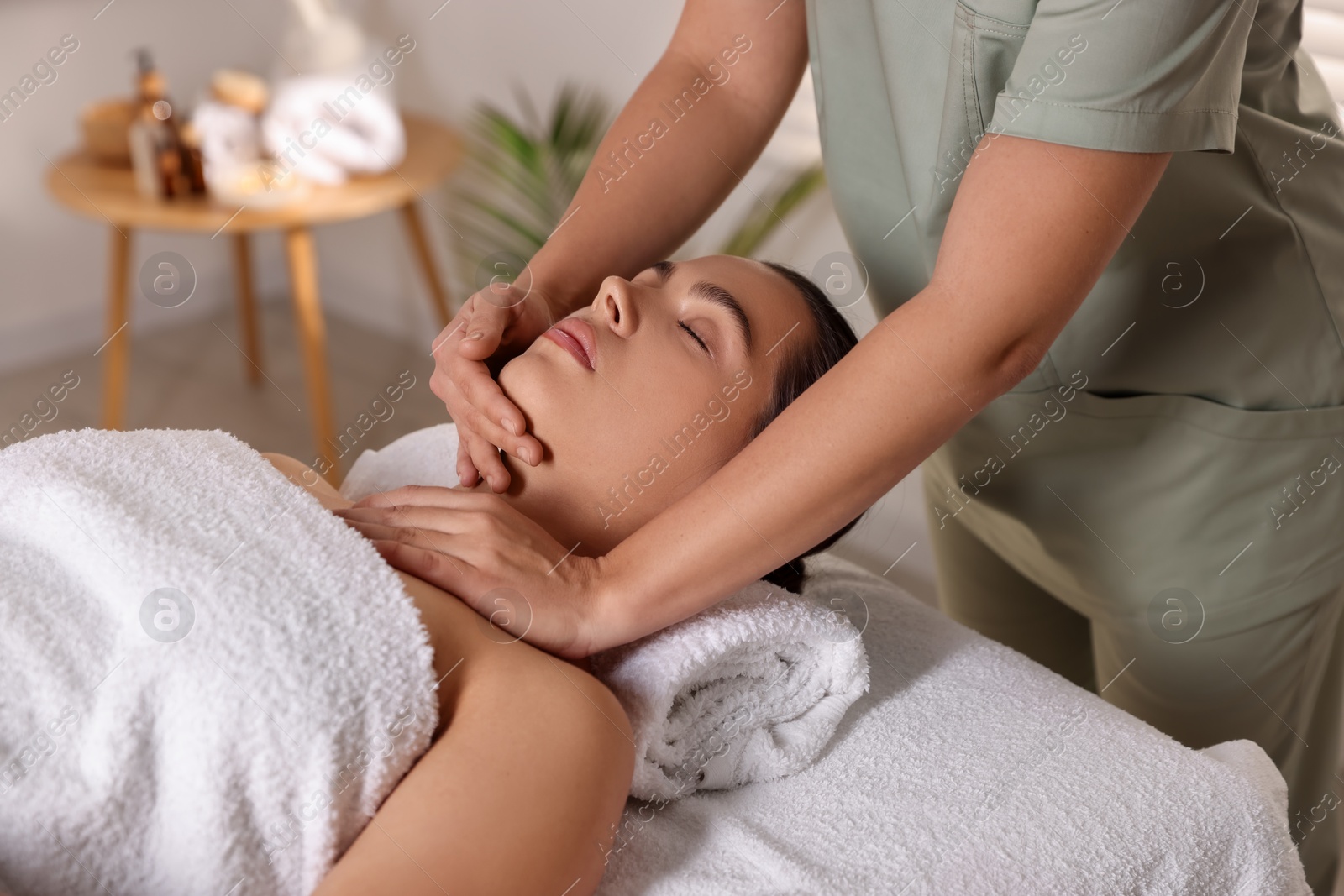 Photo of Young woman receiving massage in spa salon