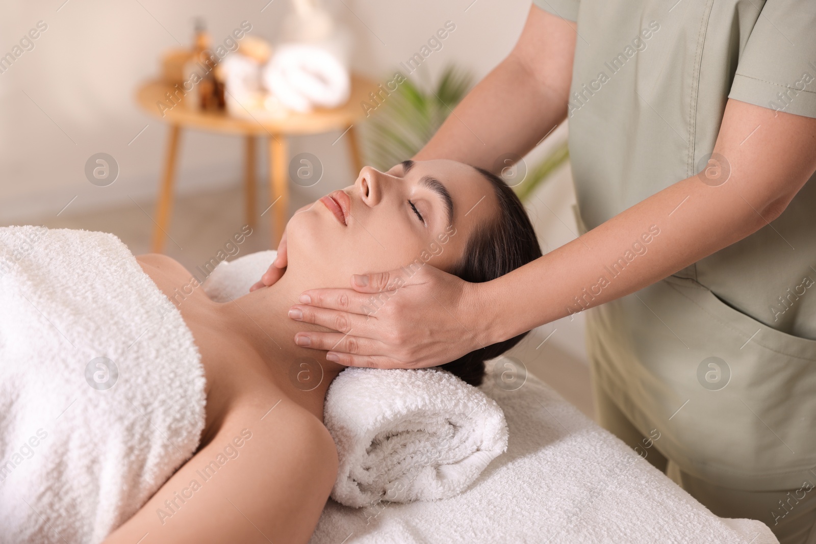 Photo of Young woman receiving massage in spa salon