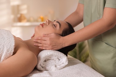 Photo of Young woman receiving massage in spa salon