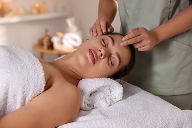 Photo of Woman receiving face massage in spa salon