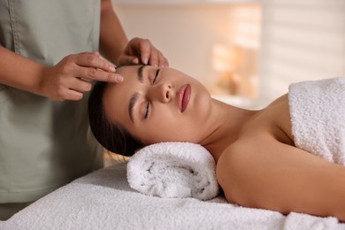 Woman receiving face massage in spa salon