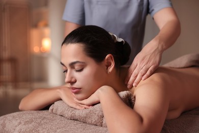 Photo of Woman receiving back massage in spa salon