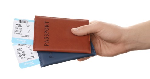 Photo of Travel agency. Man holding passports with flight tickets on white background, closeup