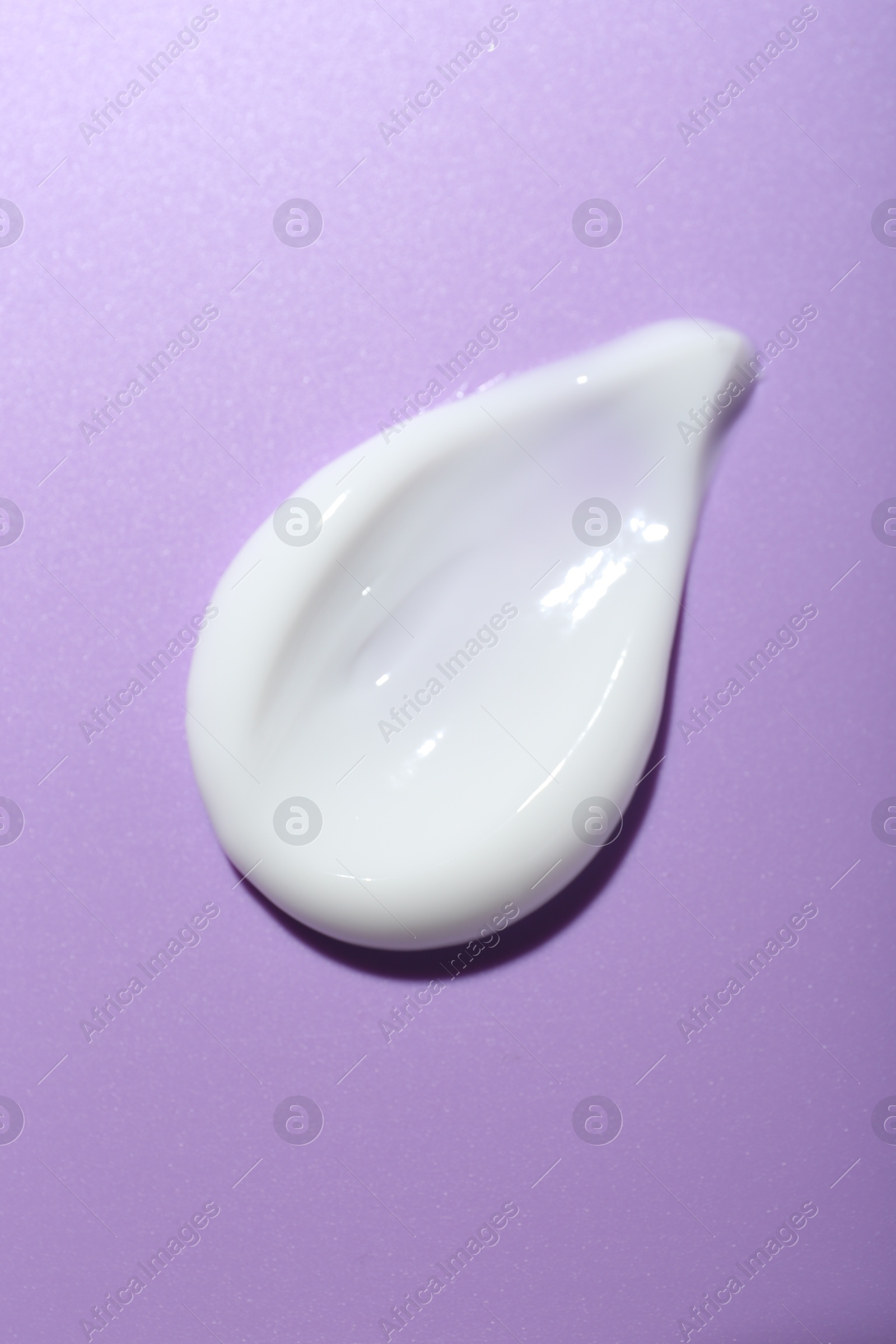 Photo of Cream sample on violet background, top view