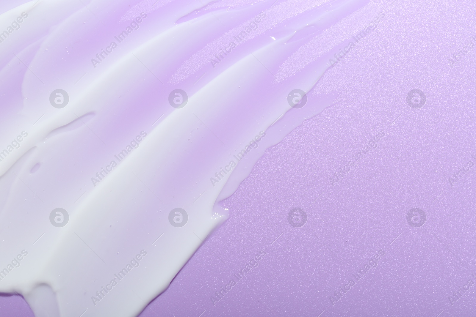 Photo of Cream sample on violet background, top view. Space for text