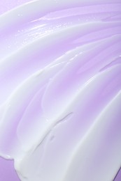 Photo of Cream sample on violet background, top view