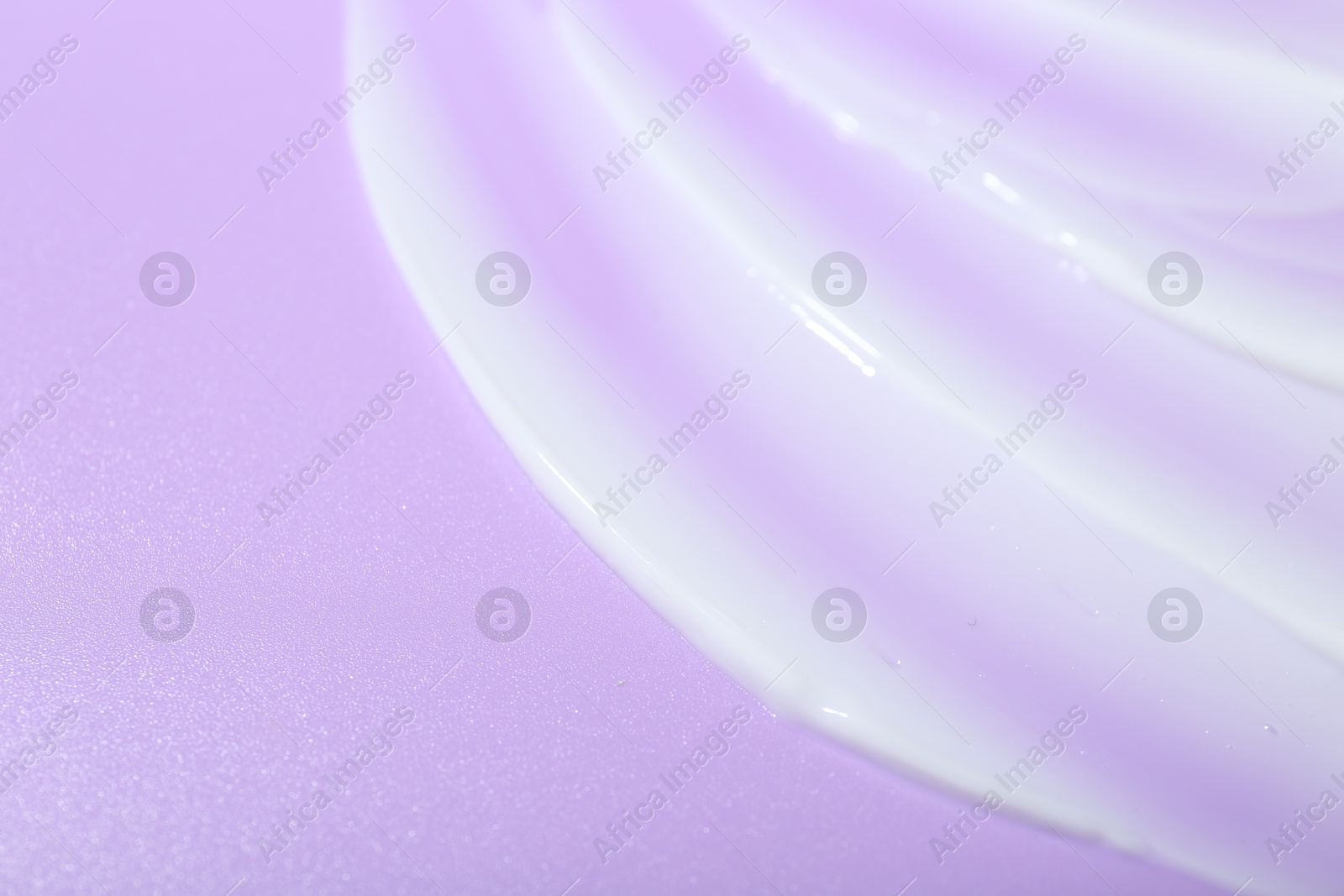 Photo of Cream sample on violet background, closeup. Space for text