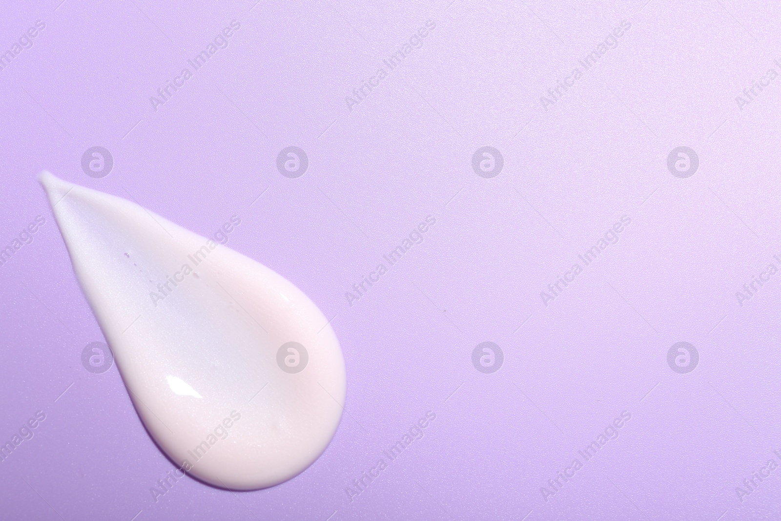 Photo of Cream sample on violet background, top view. Space for text