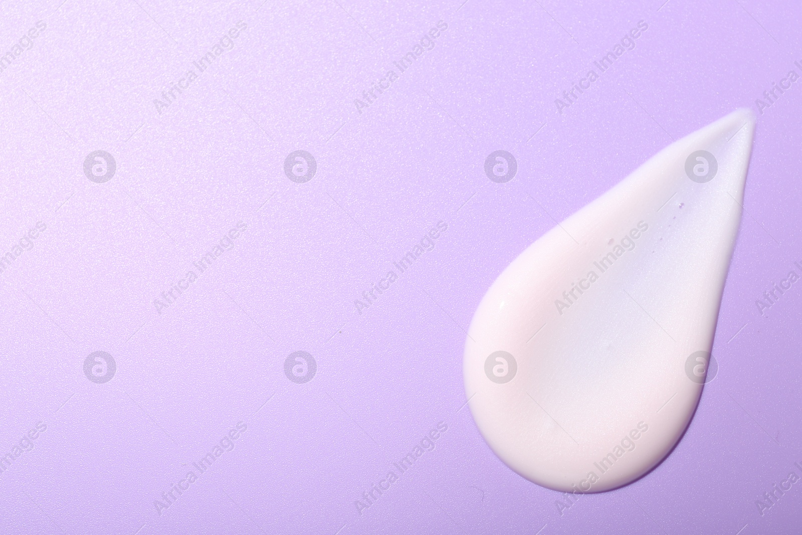 Photo of Cream sample on violet background, top view. Space for text