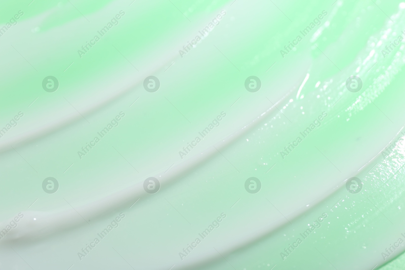 Photo of Cream sample on light green background, closeup view