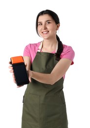 Happy young woman in apron with payment terminal on white background