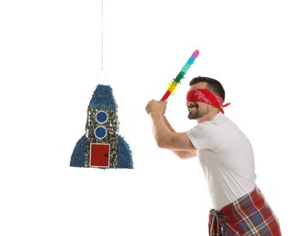 Photo of Blindfolded man hitting rocket shaped pinata with stick on white background