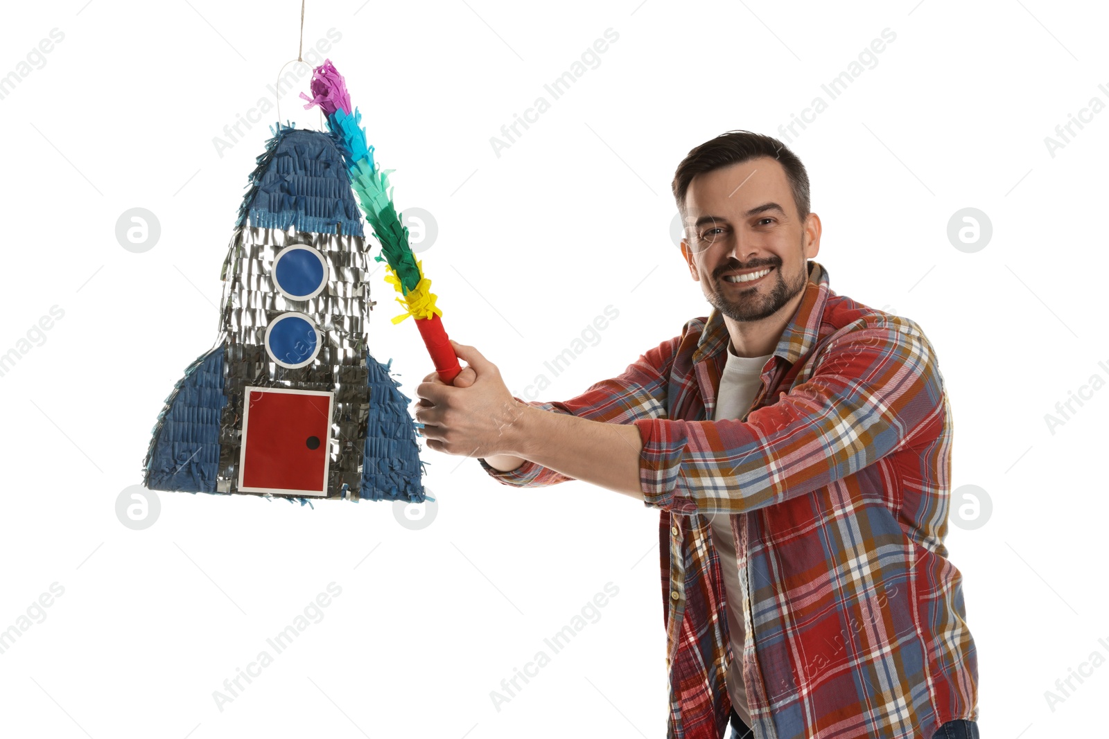 Photo of Happy man hitting rocket shaped pinata with stick on white background