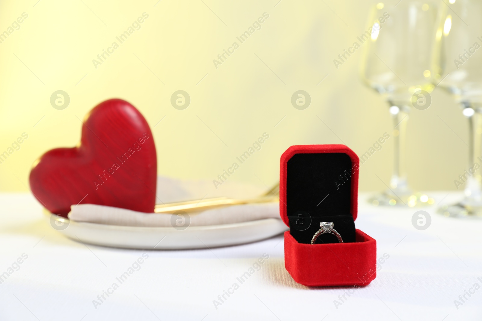 Photo of Beautiful engagement ring and setting for romantic dinner on white table