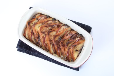 Photo of Delicious bread pudding in baking dish isolated on white, top view