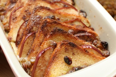 Photo of Delicious bread pudding in baking dish on table, closeup