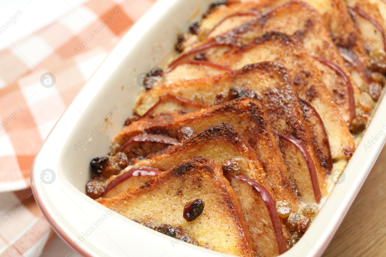 Photo of Delicious bread pudding in baking dish on table, closeup