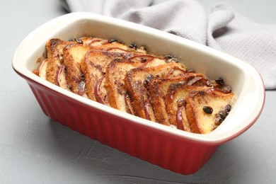 Photo of Delicious bread pudding in baking dish on light gray table, closeup