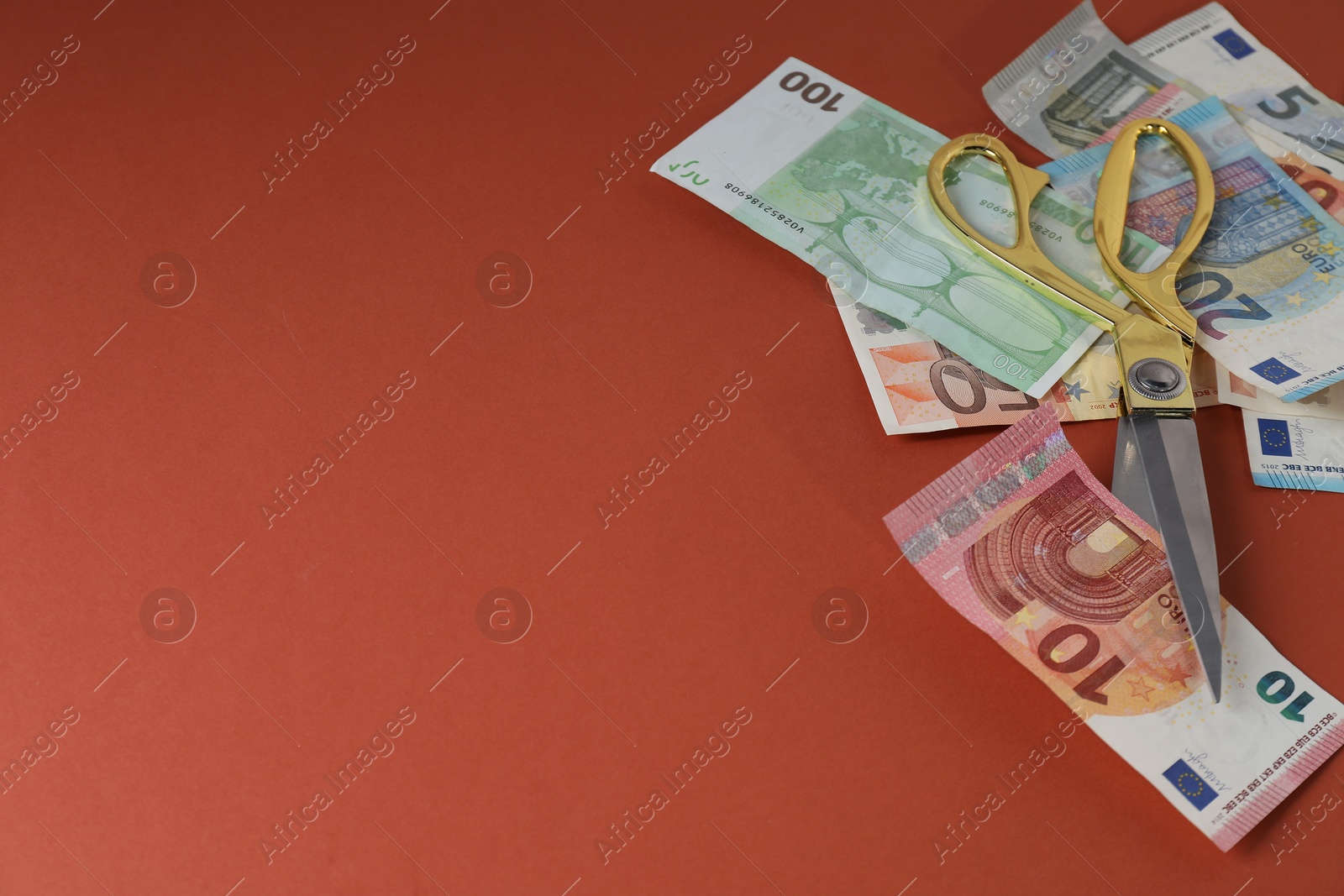 Photo of Euro banknotes and scissors on brown background, space for text