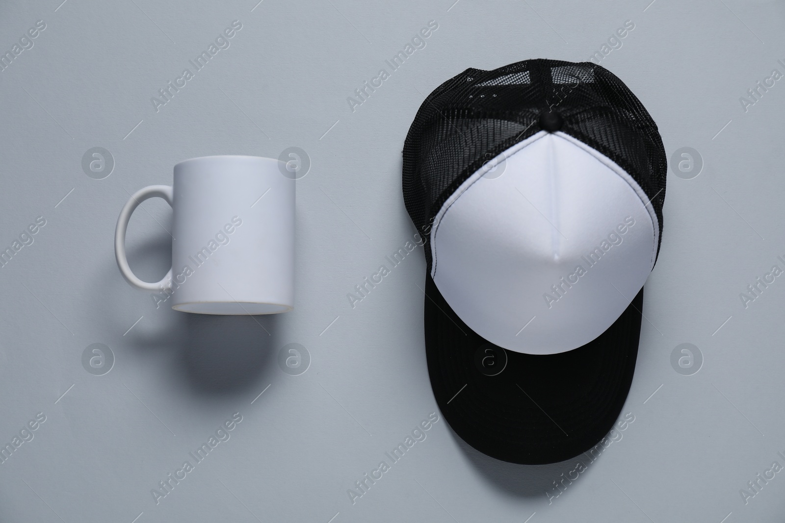 Photo of Blank cap and cup for branding on gray background, flat lay. Mockup for design