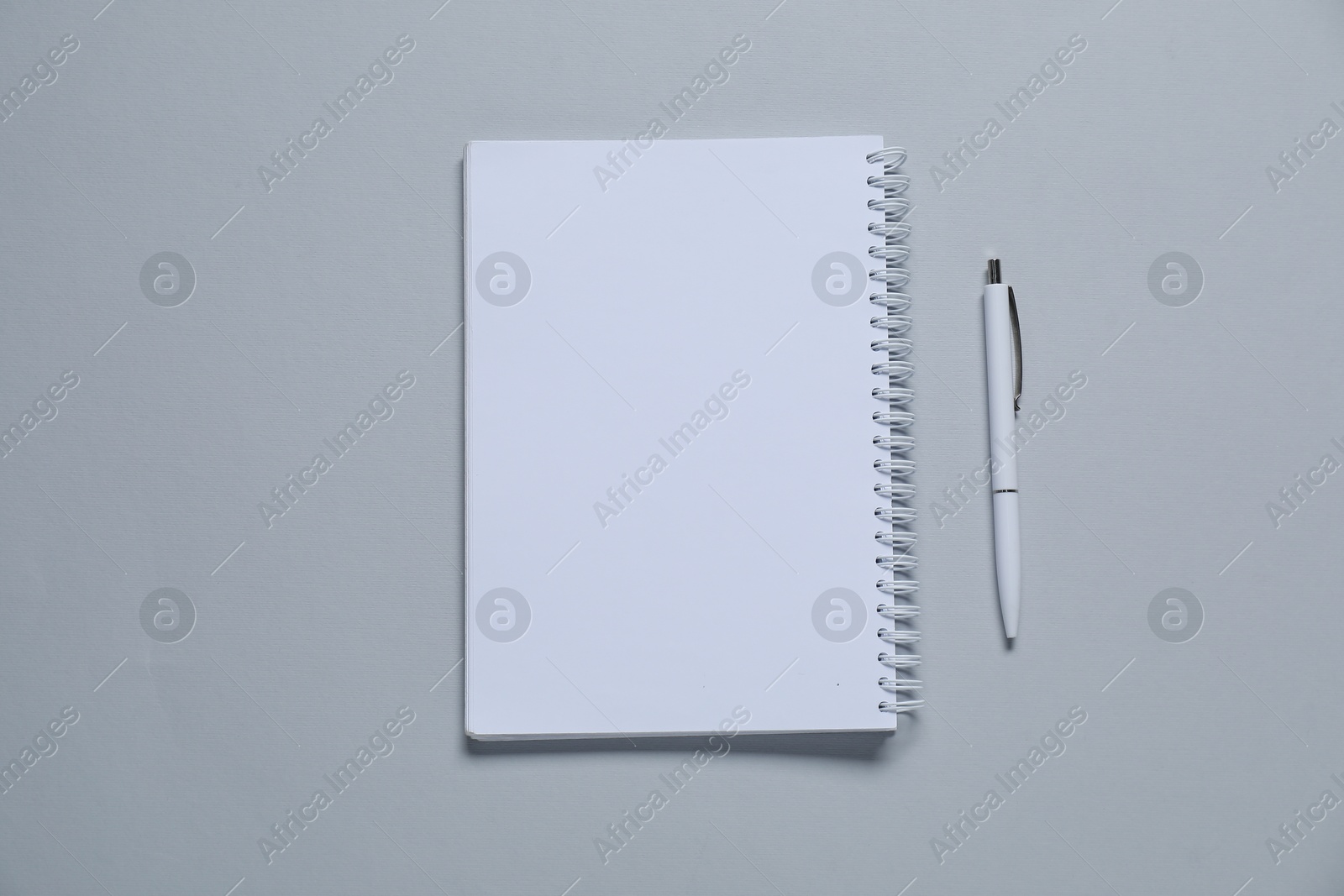 Photo of Blank notebook and pen for branding on gray background, flat lay. Mockup for design