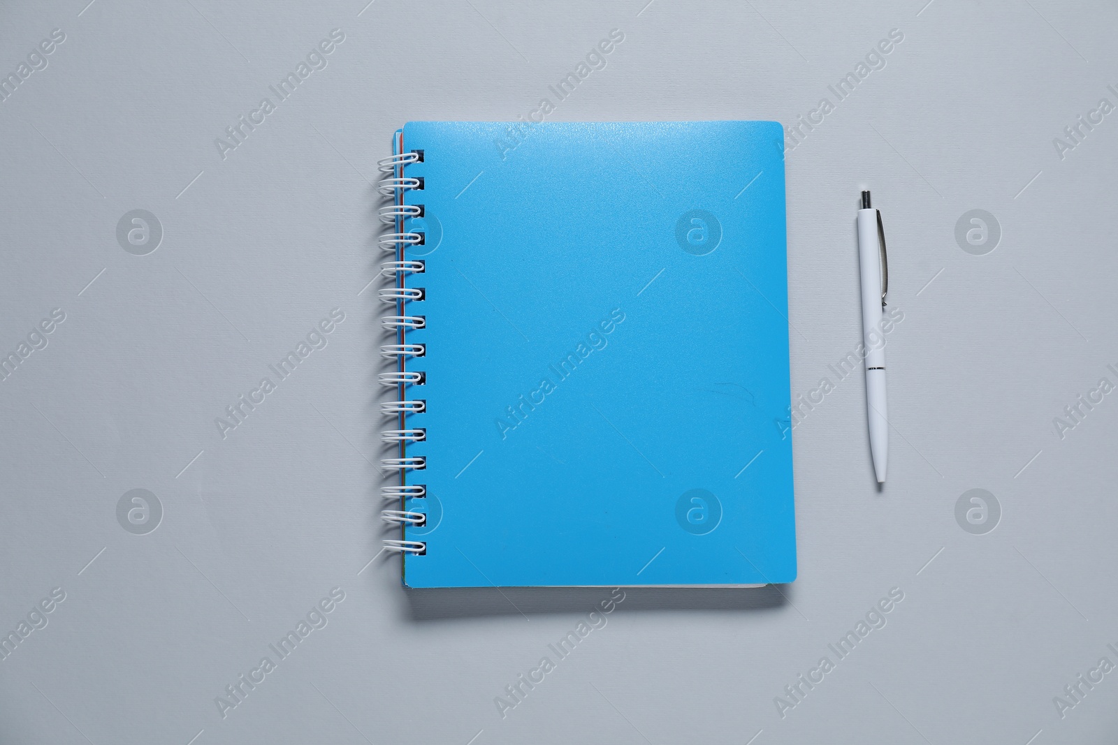 Photo of Blank notebook and pen for branding on gray background, flat lay. Mockup for design