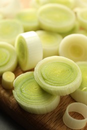 Photo of Chopped fresh leek on wooden board, closeup