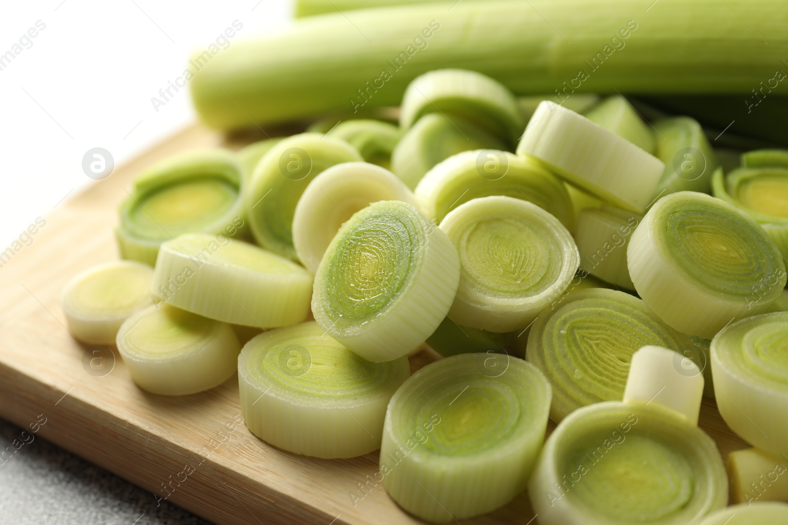 Photo of Fresh cut leeks on grey table, closeup