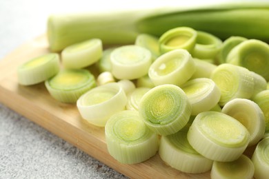 Photo of Fresh cut leeks on grey table, closeup