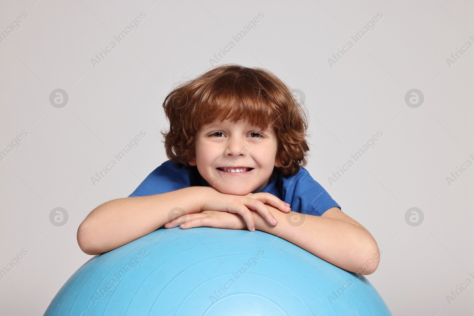 Photo of Little boy with fitness ball on light grey background