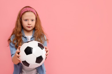 Photo of Little girl with soccer ball on pink background, space for text