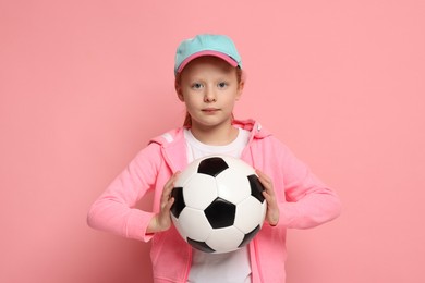 Photo of Little girl with soccer ball on pink background