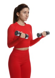 Woman in sportswear exercising with dumbbells on white background